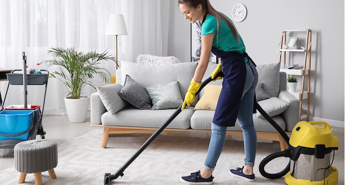 Professional cleaner vacuuming carpet