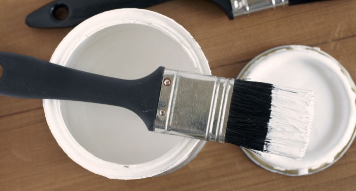 tin of gloss paint and paintbrush