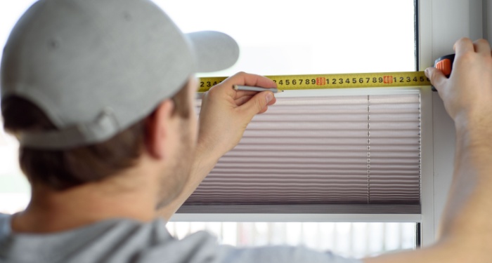 person measuring glass pane