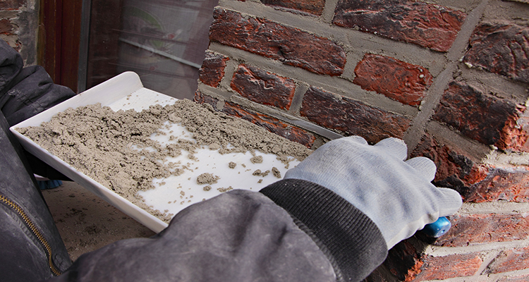 person repointing brick wall